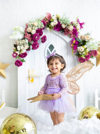 A happy little fairy exploring her magical world. The starry, cloud-filled set is perfect for creating enchanting birthday portraits.