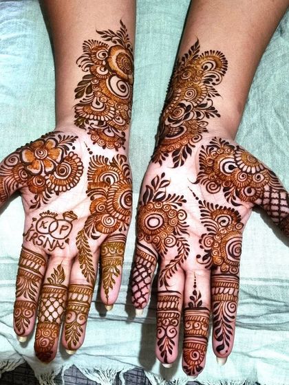 Simple and sweet for an engagement bride. This Arabic-style design includes the couple's initials inside a heart, a popular and lovely way to personalize your henna.