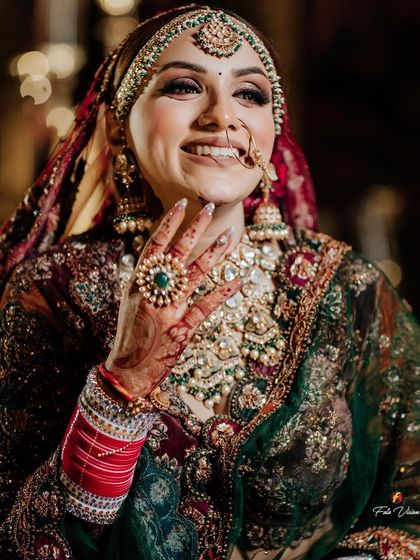 A happy and confident bridal portrait, with the bride showing off her stunning ring and henna-adorned hand.