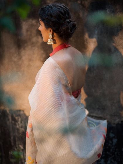 The beauty of an open-back blouse and a gracefully draped saree. This shot focuses on the silhouette and the delicate details, with the model's elegant posture and the soft lighting creating a serene and artistic mood.
