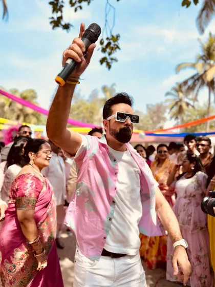 Mic in hand, ready to get the party started at a Goa destination wedding. The vibe was just perfect.