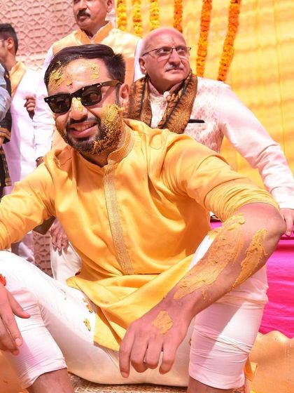 The groom, post-haldi, looking cool and happy. Even covered in turmeric, his simple yellow kurta and sunglasses make for a stylish shot.