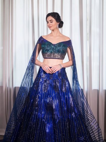 Bringing haute couture vibes to life. This stunning blue lehenga is paired with a clean, elegant makeup look for a modern engagement style.