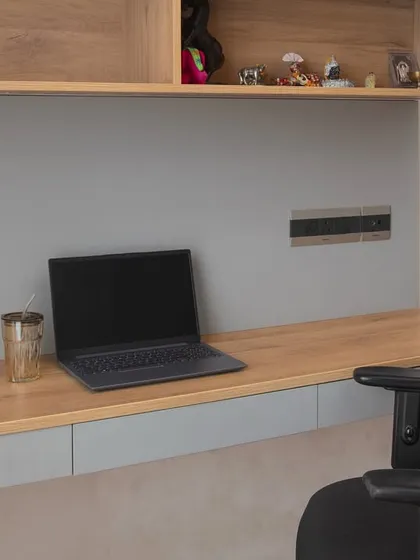 A close-up of the floating desk, showing the clean lines and seamless integration of power outlets. It’s a space designed for focus and productivity.