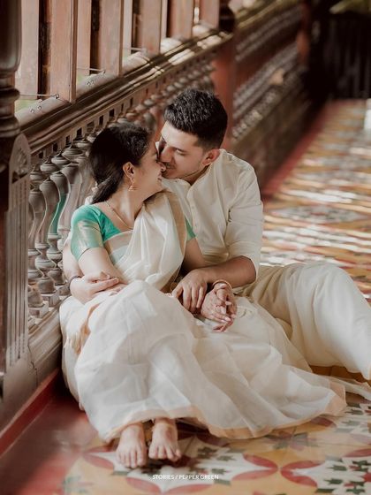 A romantic moment on the floor of a veranda, the groom giving his bride a sweet kiss.