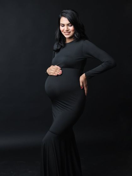 A three-quarter profile shot is perfect for showcasing the beautiful curve of the baby bump in a form-fitting dress.