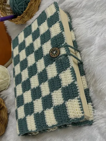 For the book lovers, I create these cozy crochet book covers. This one features a classic checkerboard pattern and a wooden button clasp to keep your current read protected in style.