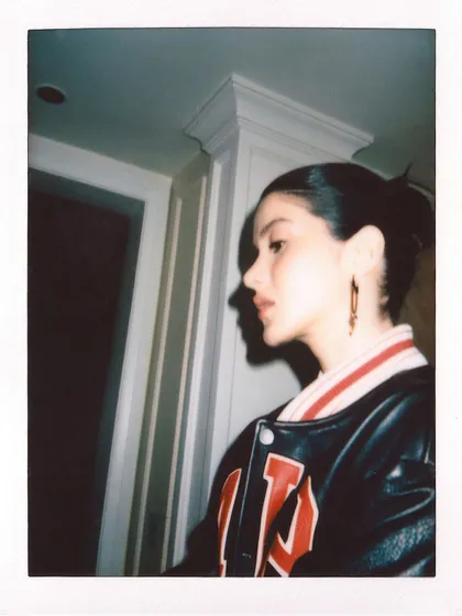 A profile shot of Shanaya Kapoor on instant film, highlighting the details of the varsity jacket.