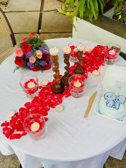An overhead view of the candlelight dinner setup, showcasing the beautiful arrangement of candles, flowers, and a custom bento cake.