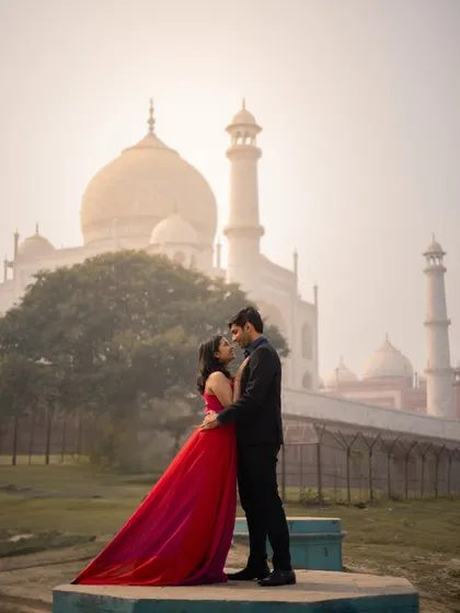 A classic, romantic pose with the couple embracing in the soft morning light, with the iconic Taj Mahal standing as a testament to their love.
