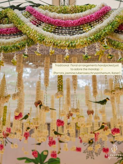 A close-up of the traditional floral arrangements we used to adorn the mandap. We handpicked auspicious elements like parrots crafted from leaves, jasmine, tuberoses, and chrysanthemums to create this intricate overhead decor.