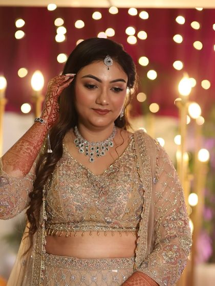 A beautiful shot of the bride-to-be against a backdrop of twinkling lights. Her glowing makeup ensures she is the center of attention.