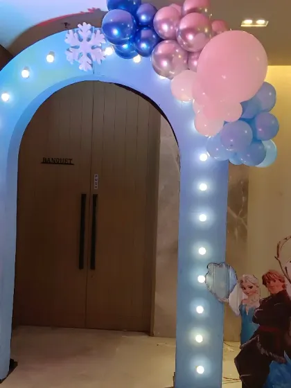 An illuminated entrance arch for a Frozen-themed party. This archway with built-in lights and character cutouts creates a magical entrance for guests arriving at the winter wonderland.