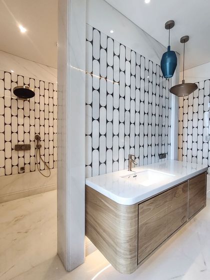 This washroom in a private residence features striking inlay tile work inspired by local artisanship. I combined Italian white marble with a custom wood vanity and warm cove lighting to create a bright space that exudes luxury and sophistication.