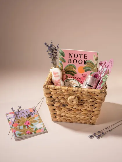 A charming gift basket from Doro filled with stationery and small gifts. The soft lighting and lavender sprigs create a gentle, thoughtful, and feminine aesthetic.