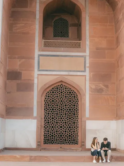 A couple sharing a quiet moment against the magnificent architecture of Humayun's Tomb. This kind of environmental portrait tells a story about both the people and the place.