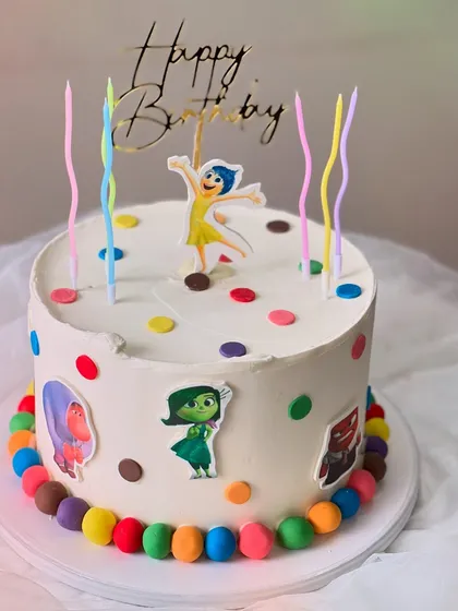 An "Inside Out" themed birthday cake made with my Belgian Chocolate flavor. It's decorated with colorful polka dots, character cutouts, and rainbow candles.
