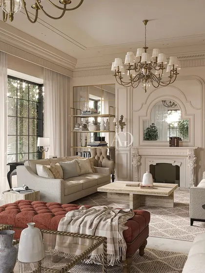 A closer look at the details of this inviting living room. The tufted ottoman in a rich terracotta adds a pop of color and texture, while the classic mantelpiece and mirrored alcoves enhance the room's sophisticated, European-inspired character.