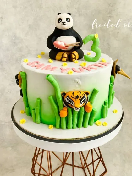 The full Kung Fu Panda themed cake, with Po on top and other characters like Tigress peeking through the bamboo stalks.