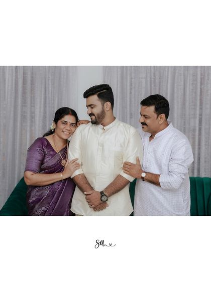 The 'Kalyanachekkan' (groom) with his proud parents. A simple, elegant cream kurta for a traditional engagement or pre-wedding ceremony.