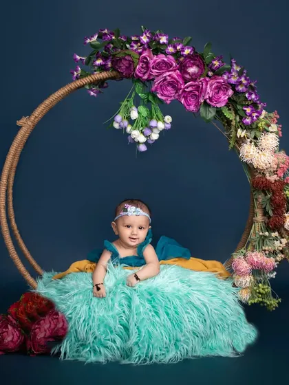 A vision in turquoise and flowers. This artistic portrait features a custom floral hoop, creating a unique and elegant frame for this beautiful baby girl.