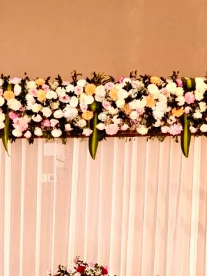 A close-up of the lush floral runner made with fresh roses and chrysanthemums, which topped the backdrop for a naming ceremony.
