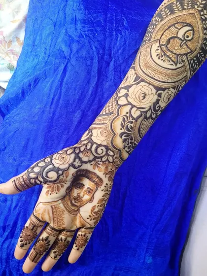 This portrait henna was for a bride who wanted her groom's face on her palm. I combined the portrait with floral and peacock elements for a complete and beautiful design.