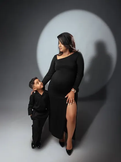 A beautiful moment between a mother and her son. This shot captures the special bond they share as they await the new arrival, styled in matching black outfits.