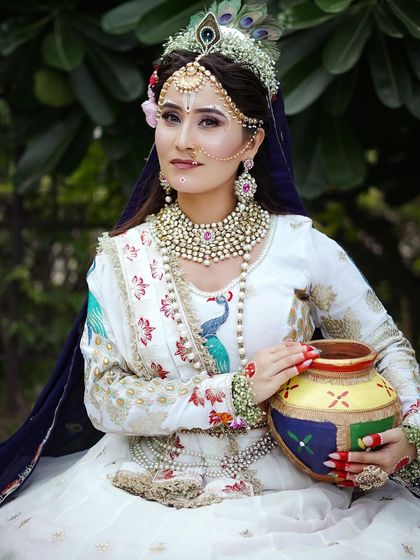 This close up shows the detailed makeup, including the traditional white sandalwood markings and peacock feather crown. I teach students to pay close attention to authentic details.