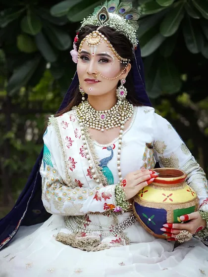 This close up shows the detailed makeup, including the traditional white sandalwood markings and peacock feather crown. I teach students to pay close attention to authentic details.