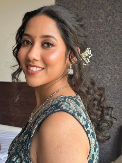 A close-up of the hairstyle, featuring a delicate arrangement of fresh flowers that adds a touch of romance to the look.