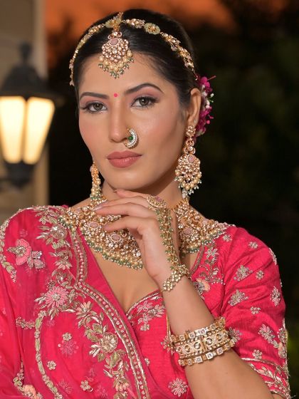 A complete bridal look featuring a heavy, gold-plated Kundan necklace, haath phool, and maang tikka, all available for rent.