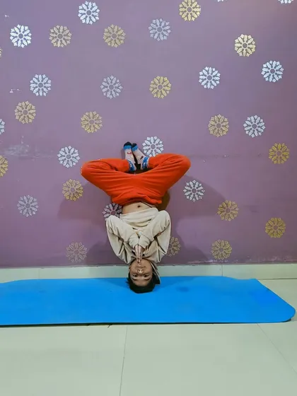 This young champion mastering the headstand (Sirsasana). I guide clients of all ages to safely achieve their fitness goals.