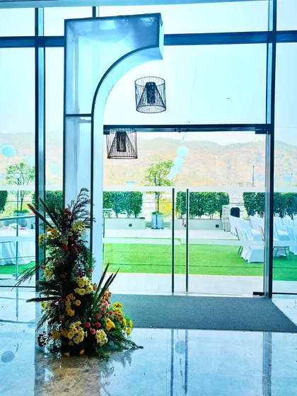 An example of our indoor decor details. This modern archway with hanging cage lamps perfectly frames the view of the outdoor lawn, seamlessly connecting the indoor and outdoor spaces of the venue.