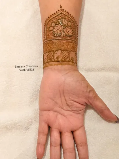 The back of the hand, showing a beautiful cuff design with elephants and a jharokha-style window.