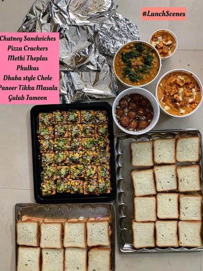 Another view of the lunch order with sandwiches, crackers, and curries.