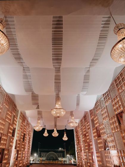An elegant entrance corridor with cascading chandeliers and candle-lit walls. This is an example of how we transform spaces to create a grand and welcoming atmosphere.