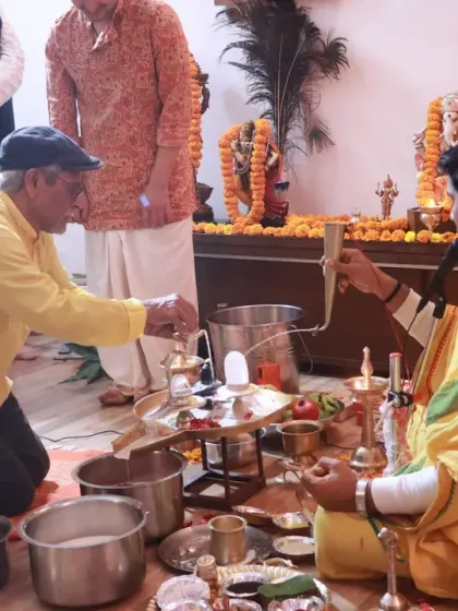 A senior member of our community participates in the puja, representing the continuity of tradition across generations.