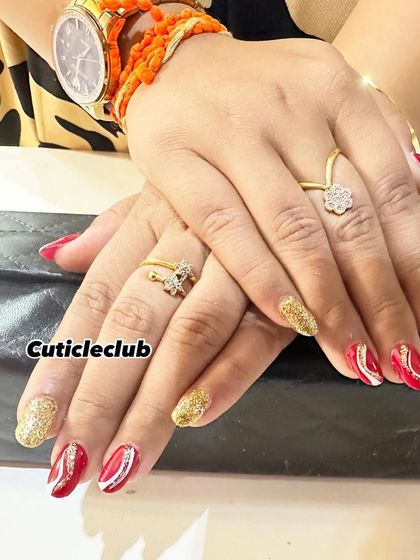 A festive combination of red, white, and gold. This set features gold glitter accent nails and red nails with hand-painted white swirls.