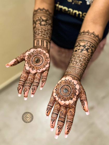 A classic bridal look with large, detailed mandalas as the centerpiece on each palm. The arms are decorated with bands of traditional patterns, creating a timeless design.