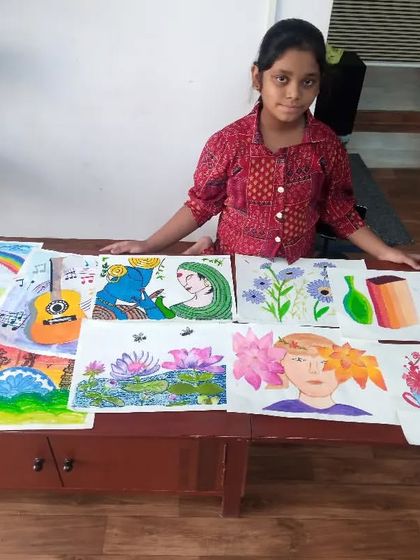 Rishita, a 4th-grade student, with a collection of her artwork from the year. It's wonderful to see the variety of mediums she has explored, including watercolors, oil pastels, and poster colours.