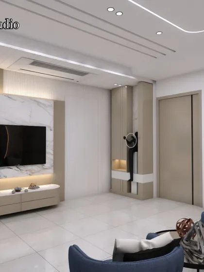 A modern living room where a marble-backed TV unit serves as the centerpiece. The combination of plush blue armchairs and neutral tones creates a balanced and sophisticated look.