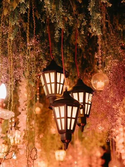 A close-up of the hanging lanterns and pink wisteria in the enchanted forest ceiling, showcasing the layered details that create a sense of depth and magic.
