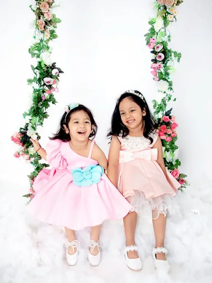 The sweetest smiles between two sisters. Our floral swing set is perfect for capturing the magical bond between siblings, creating a light, airy, and joyful portrait they will cherish forever.
