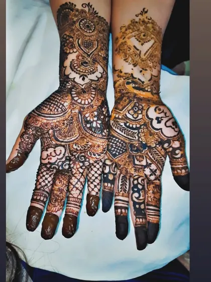 A perfect example of asymmetrical bridal mehendi, where each hand tells a different part of the story. One hand features traditional patterns, while the other incorporates unique, personal symbols.
