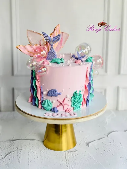 Making waves with this magical mermaid cake. This design features a beautiful mermaid tail, seashells, and underwater treasures.