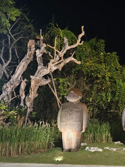 An interesting stone sculpture with a unique form, illuminated at night to create a dramatic effect in the garden.