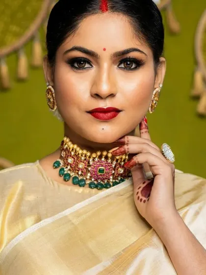 A simple and elegant look with a gold tissue saree. The makeup is classic, with a red lip and kohl-rimmed eyes.