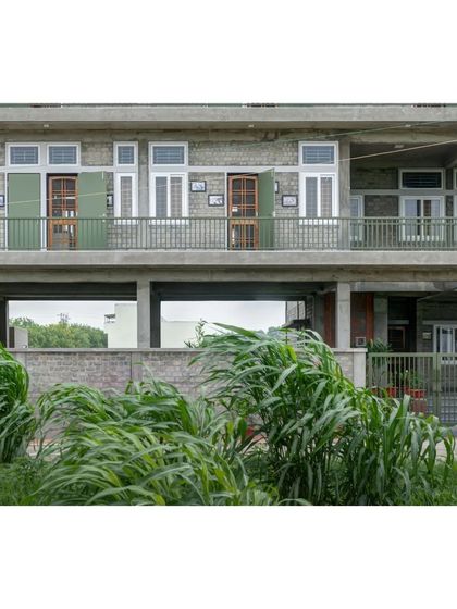 The facade of the ASA office, showing the open ground floor that allows wind and nature to pass through. This passive design strategy, along with deep overhangs, helps keep the entire building cool.