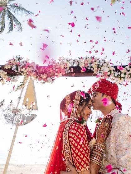 A tender kiss on the forehead under a shower of petals. This romantic moment from a Goa wedding is what fairytales are made of.
